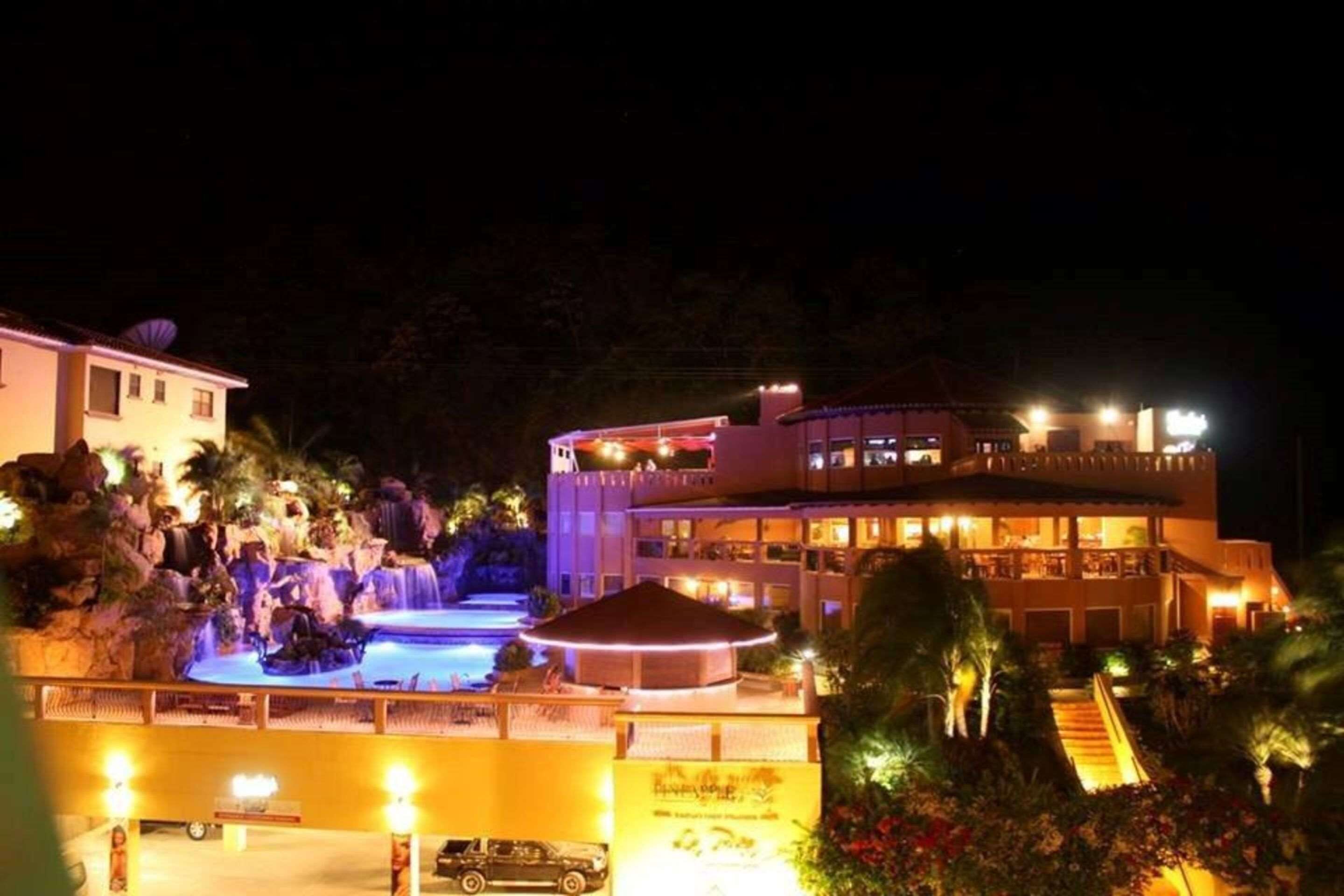 Un resort con piscina, area coperta e un edificio con numerosi balconi.