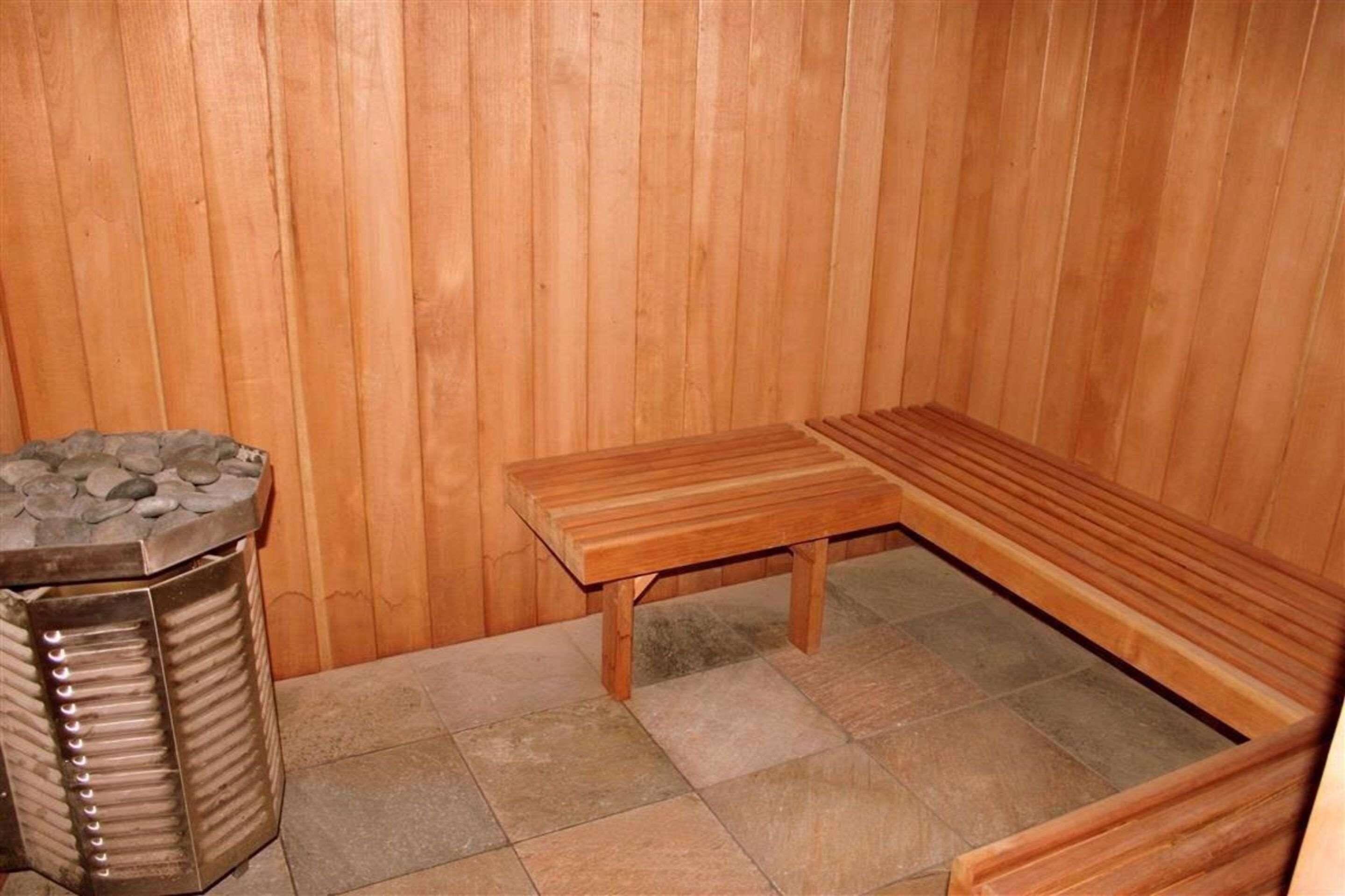 Un sauna avec des murs en bois et un banc.