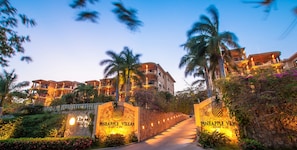 En entré till semesteranläggningen, med stenmurar och en skylt som visar vägen till Pineapple Villas.