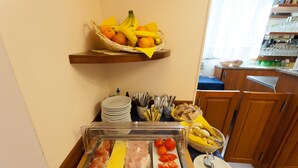 Montaje tipo bufé con una variedad de alimentos, como carnes, quesos y frutas.
