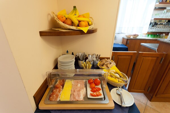 Ein Buffet mit verschiedenen Speisen, darunter Fleisch, Käse und Obst.