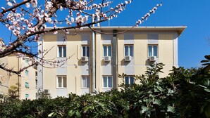 Un edificio de varios pisos con balcones y unidades de aire acondicionado.