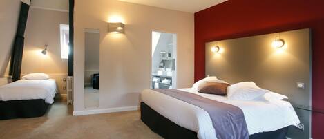A modern bedroom with two beds, a large mirror, and built-in lighting.