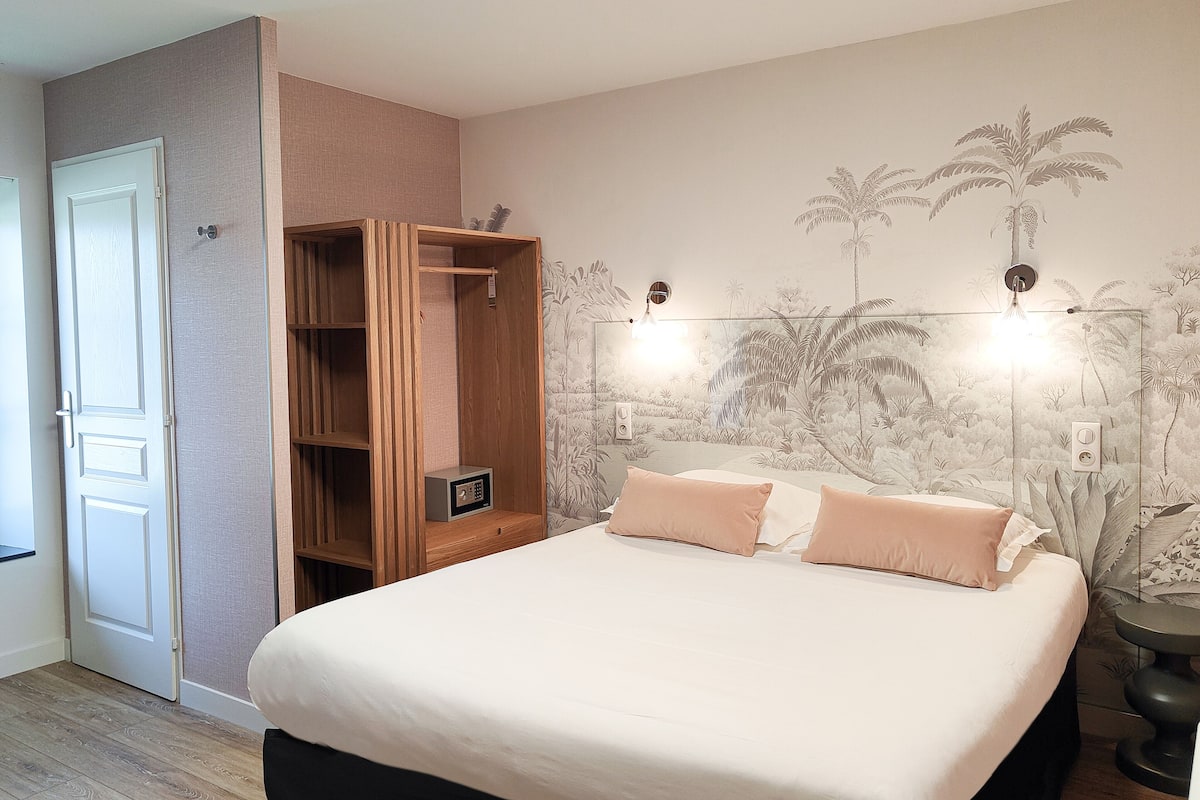 Ein Schlafzimmer mit Bett, Kleiderschrank und einer Wand mit einem Wandbild zum Thema Natur.