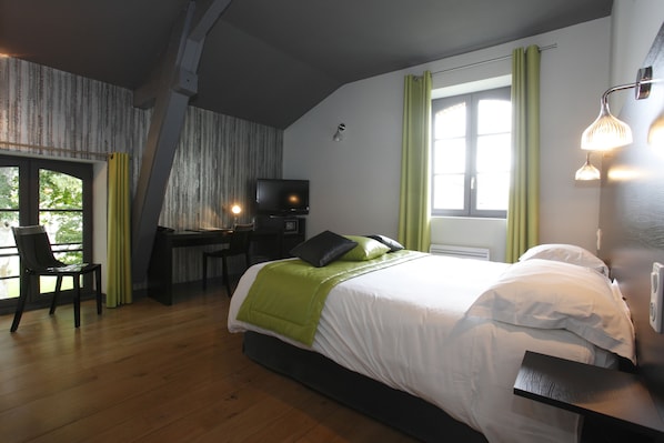 A bedroom with a bed, a desk, a chair, and a television. - Château de la Barbinière (Saint-Laurent-sur-Sevre)
