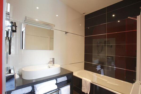 A modern bathroom with a large bathtub, a round sink, and a mirror above the sink. - Château de la Barbinière (Saint-Laurent-sur-Sevre)