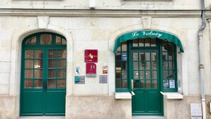 Fachada de edificio con dos puertas verdes, una con la etiqueta "Le Voeu" y la otra "CITETEL".