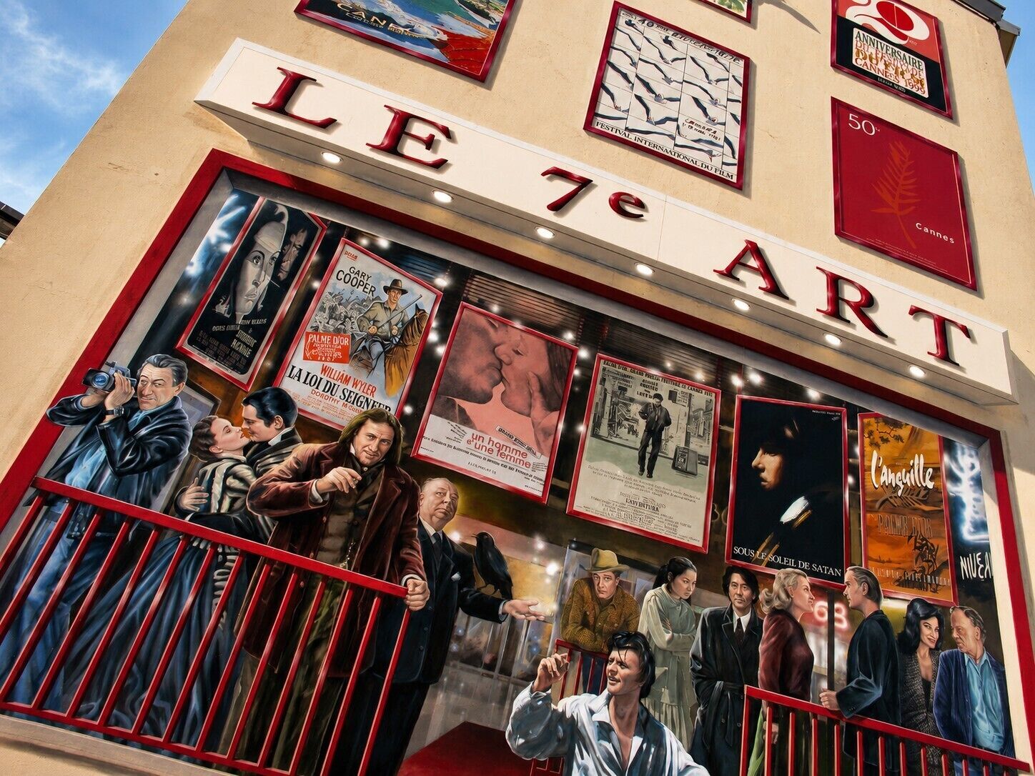 Un cinéma dont le devant est orné d’une enseigne lumineuse affichant des affiches de films et le nom « LE 7e ART ».