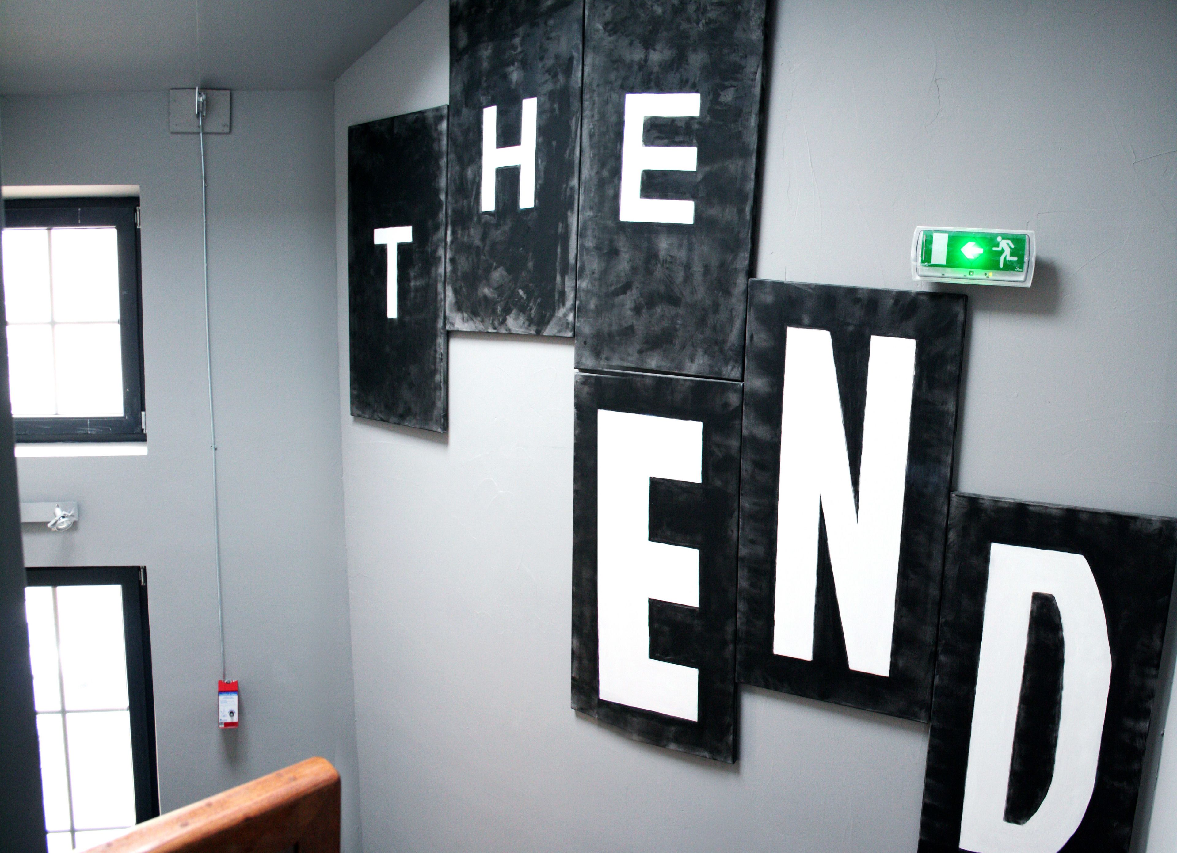Een muur met grote letters die 'THE END' vormen, in een moderne, abstracte stijl.