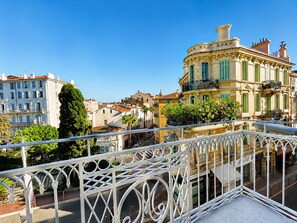 A balcony with ornate metal railings overlooking a street with buildings. - 7 Art Hotel Cannes (Cannes)