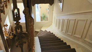 Eine Treppe mit Geländer und einem gemusterten Teppich.