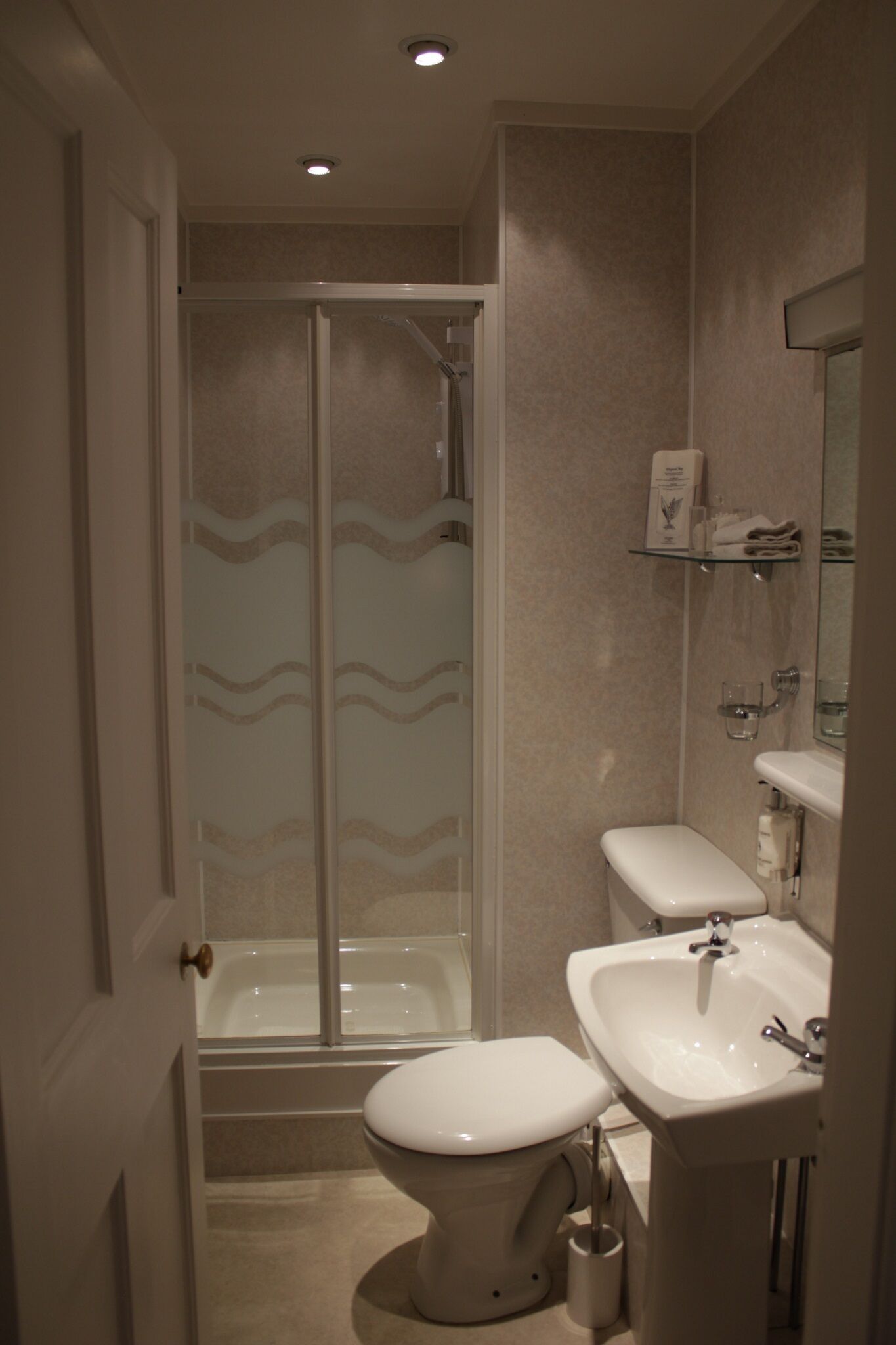 Een badkamer met toilet, wastafel en douche.