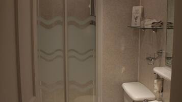 Een badkamer met toilet, wastafel en douche.