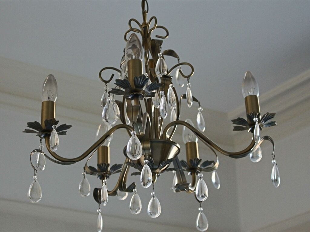 Un lustre à plusieurs bras, orné de décorations en cristal.