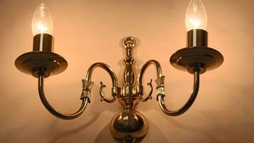 Een wandlamp met drie armen en twee lichtbollen.