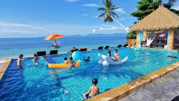 Una piscina al aire libre, sombrillas, sillones reclinables de piscina