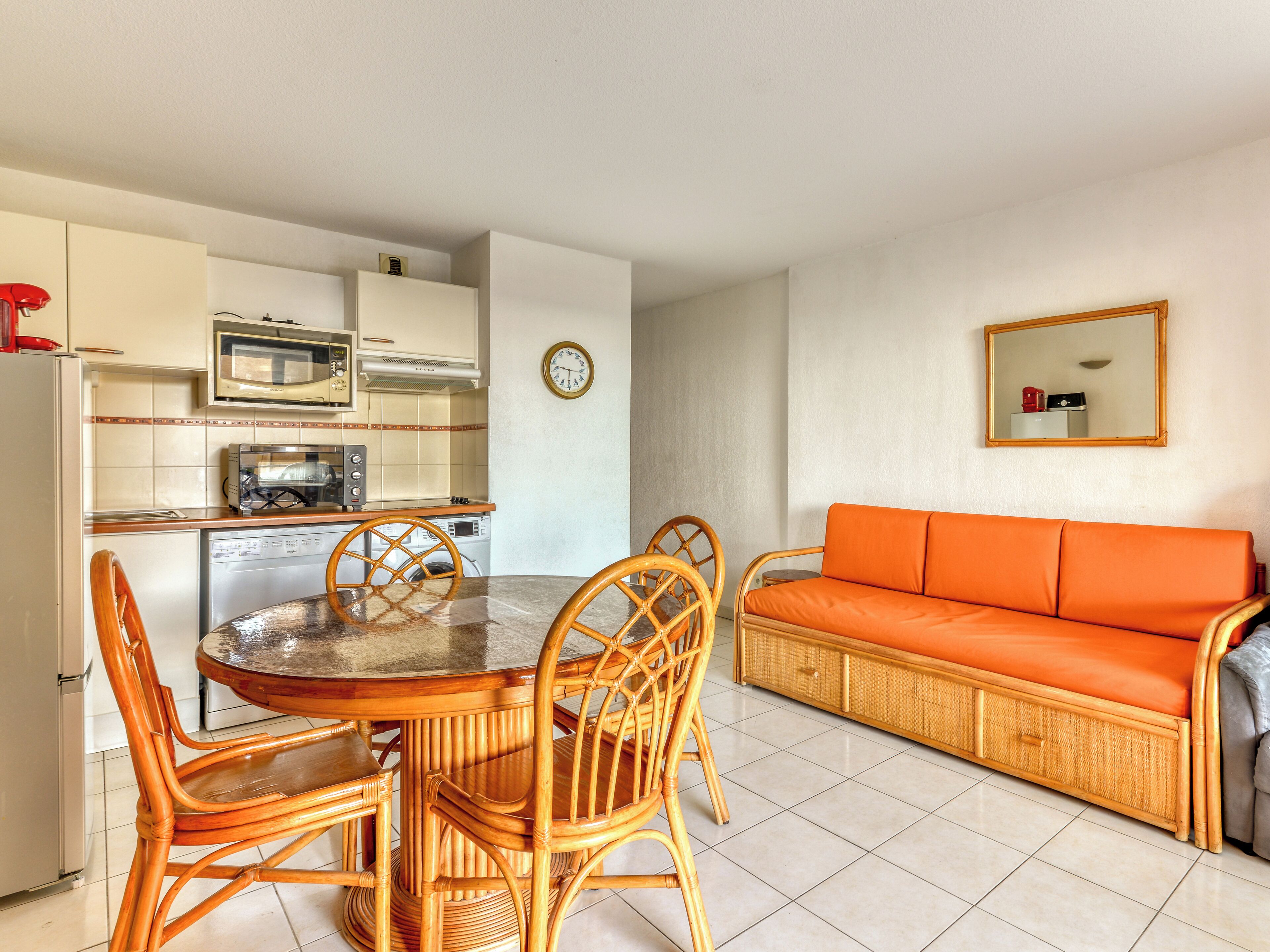 Un espacio habitable compacto con comedor, kitchenette y sofá.