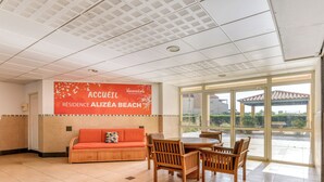 Una habitación amplia con un gran ventanal, un sofá y una mesa de comedor con sillas.