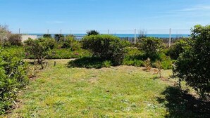 Zona verde al aire libre con cerca y árboles, que da a una masa de agua.