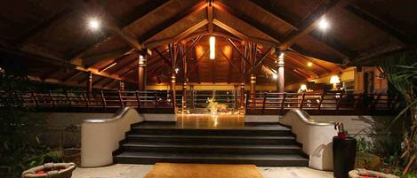 An indoor area with a wooden ceiling and steps leading to a central area with a light fixture.