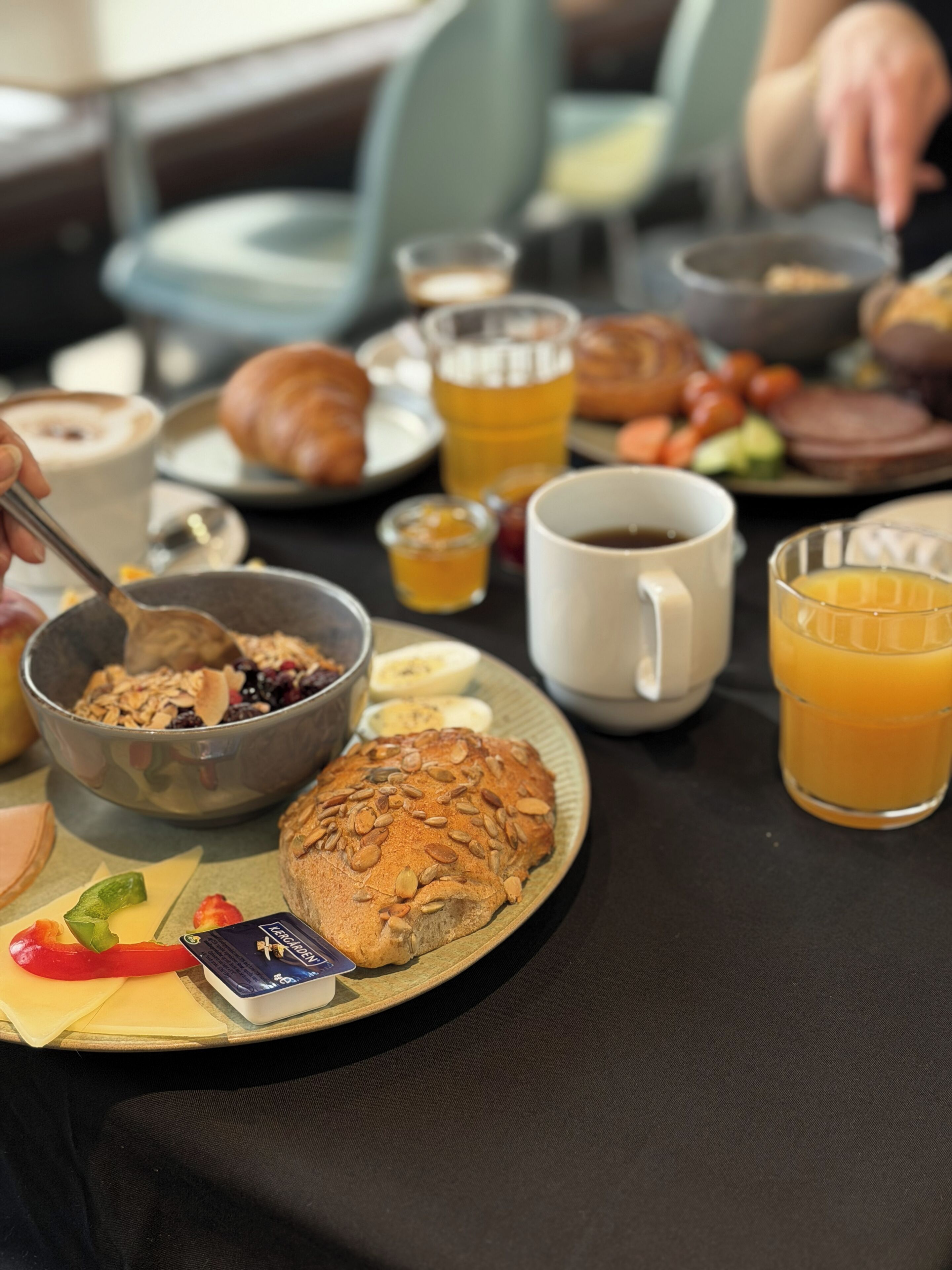 A breakfast setting with a plate of food, a mug, and a glass of orange juice.