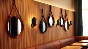 Ein Restaurant mit Holzvertäfelung, runden Spiegeln und einer Polsterbank-Sitzgruppe.