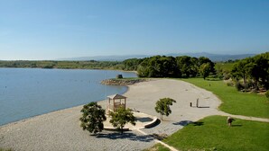 A lakeside park with a gazebo, walking paths, and a grassy area.