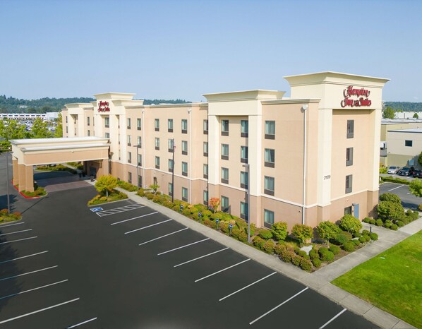 A Hampton Inn & Suites hotel with a parking lot and a landscaped area.
