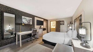 A modern hotel room with a large bed, a desk, a flat-screen TV, a desk lamp, and a globe lamp. - Aiden by Best Western South Reno (Reno)