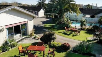 Una propiedad residencial con un patio, piscina y césped bien cuidado.