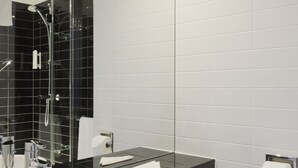 A modern bathroom with a white sink, black countertop, and white toilet. - Holiday Inn Express Manchester CC - Oxford Road by IHG (Manchester)