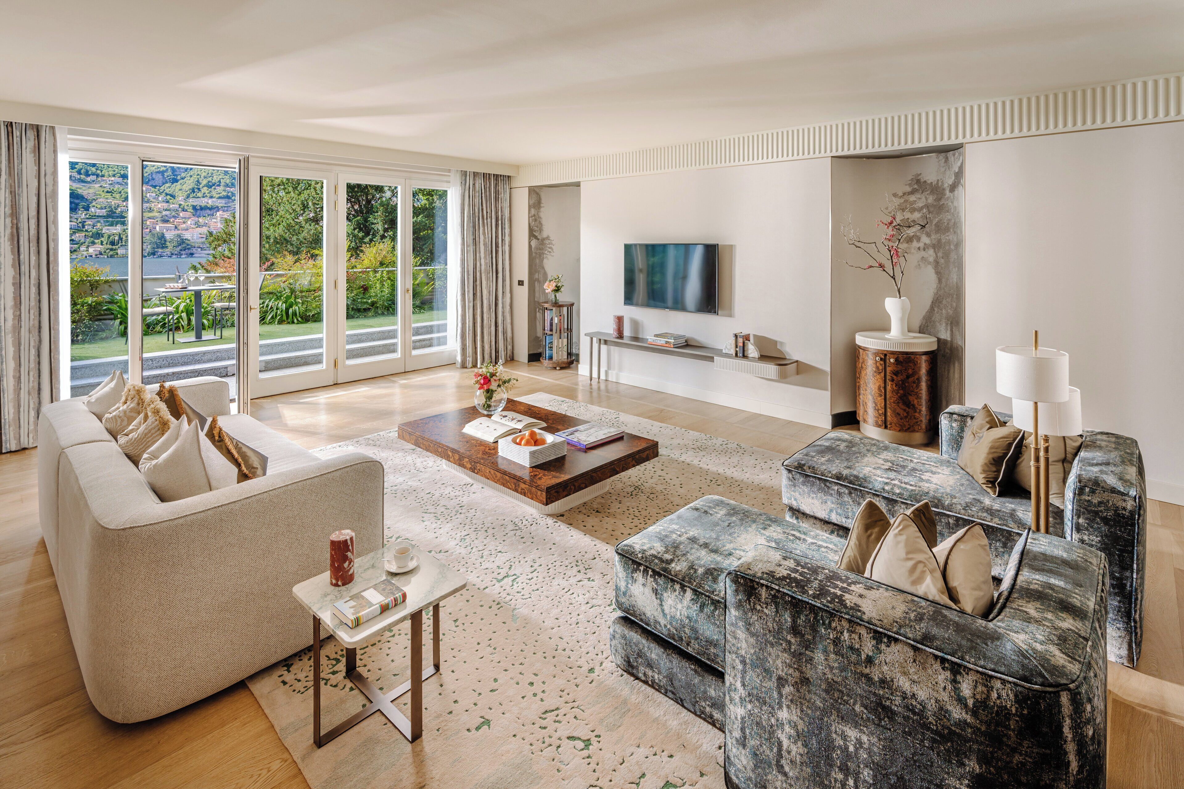 Un salón espacioso con un sofá grande, una mesa de centro y un televisor sobre un mueble.