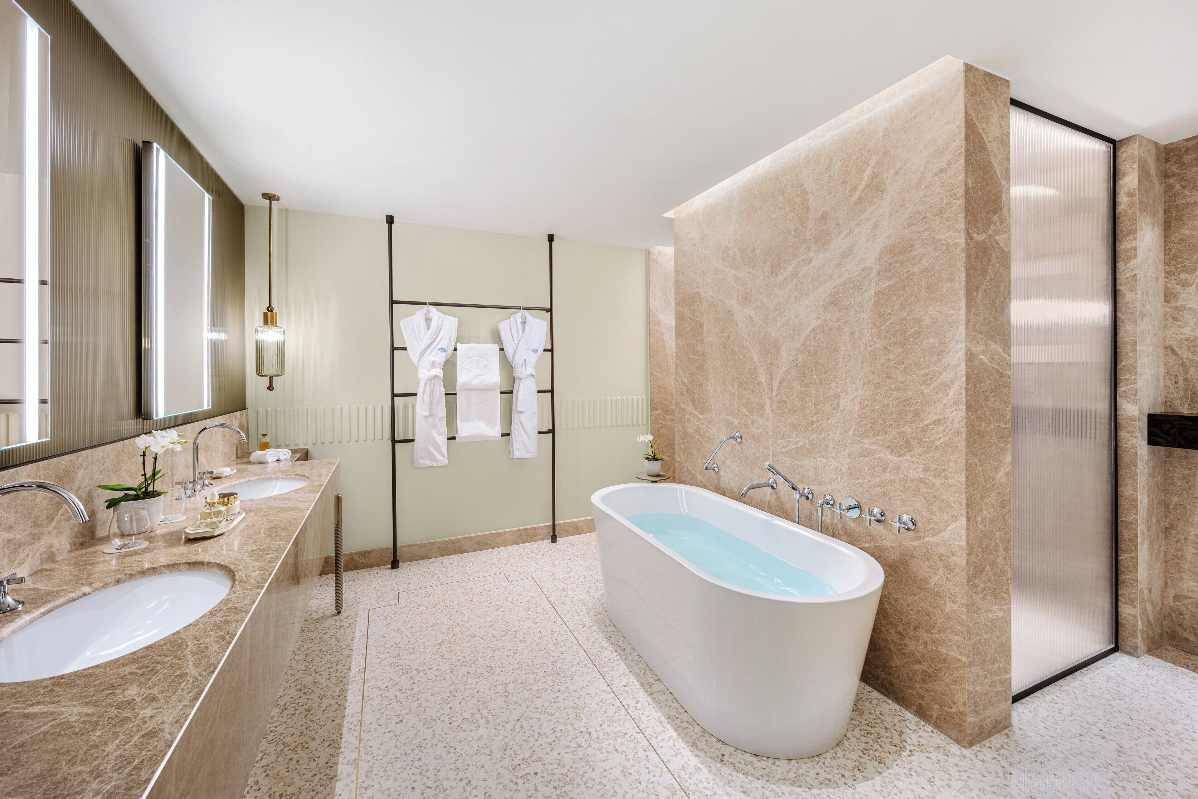 Un bagno moderno con una vasca da bagno indipendente, due lavabi e un grande specchio.