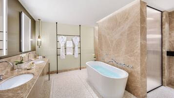 Un bagno moderno con una vasca da bagno indipendente, due lavabi e un grande specchio.