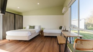 A modern room with two beds, a dining table, and a chair. - Amadiya Port Arthur Villas (Port Arthur)