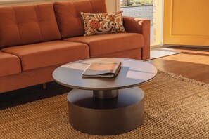 A modern living room with a round coffee table, a sofa, and a patterned pillow. - Amadiya Port Arthur Villas (Port Arthur)