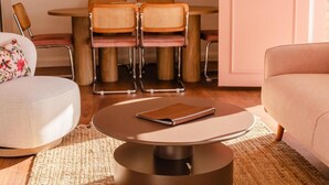A modern living room with a round coffee table, a sofa, and a dining area with a table and chairs. - Amadiya Port Arthur Villas (Port Arthur)
