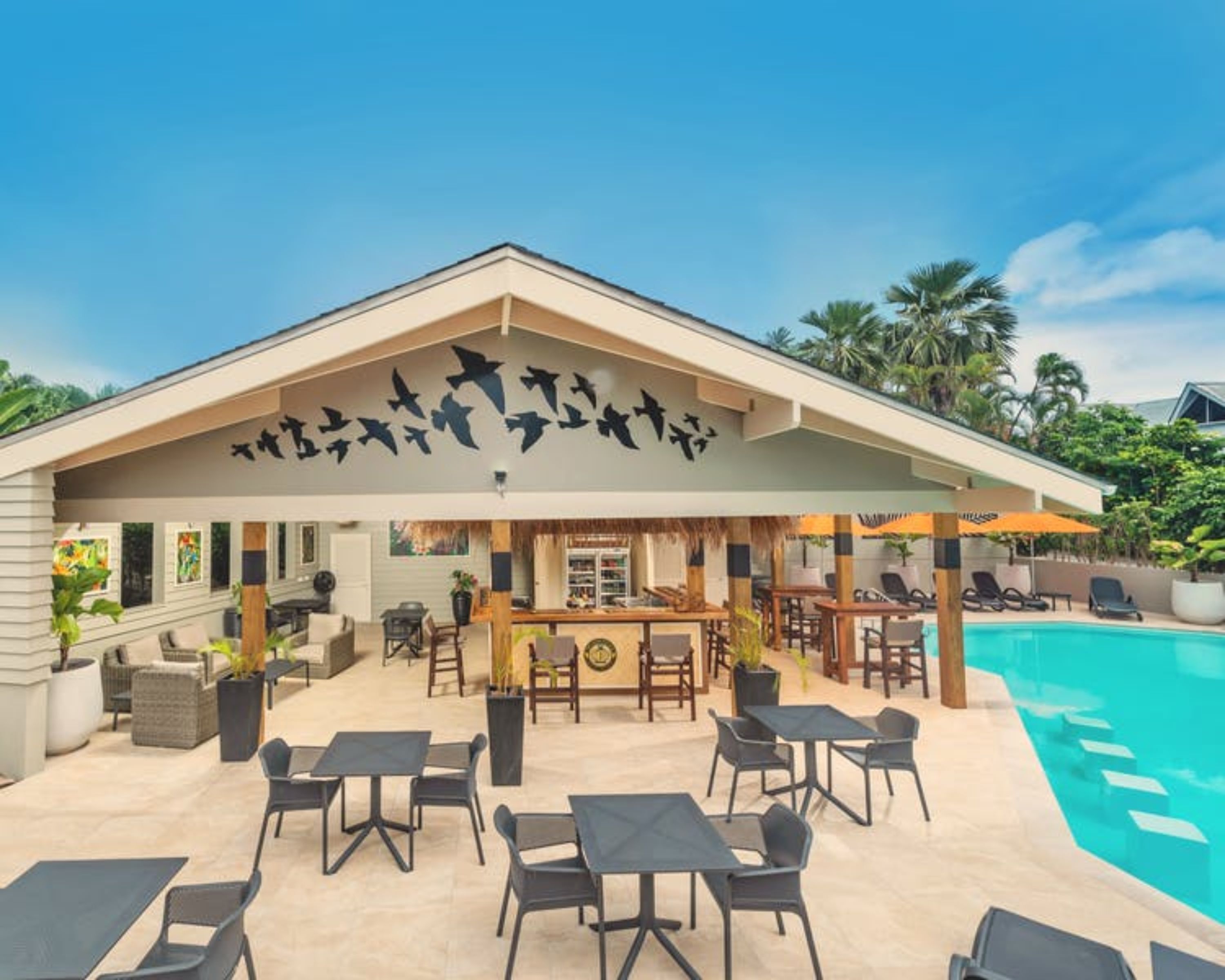 Un complex turístic amb piscina, zones d'estar a l'exterior i un bar de tiki.