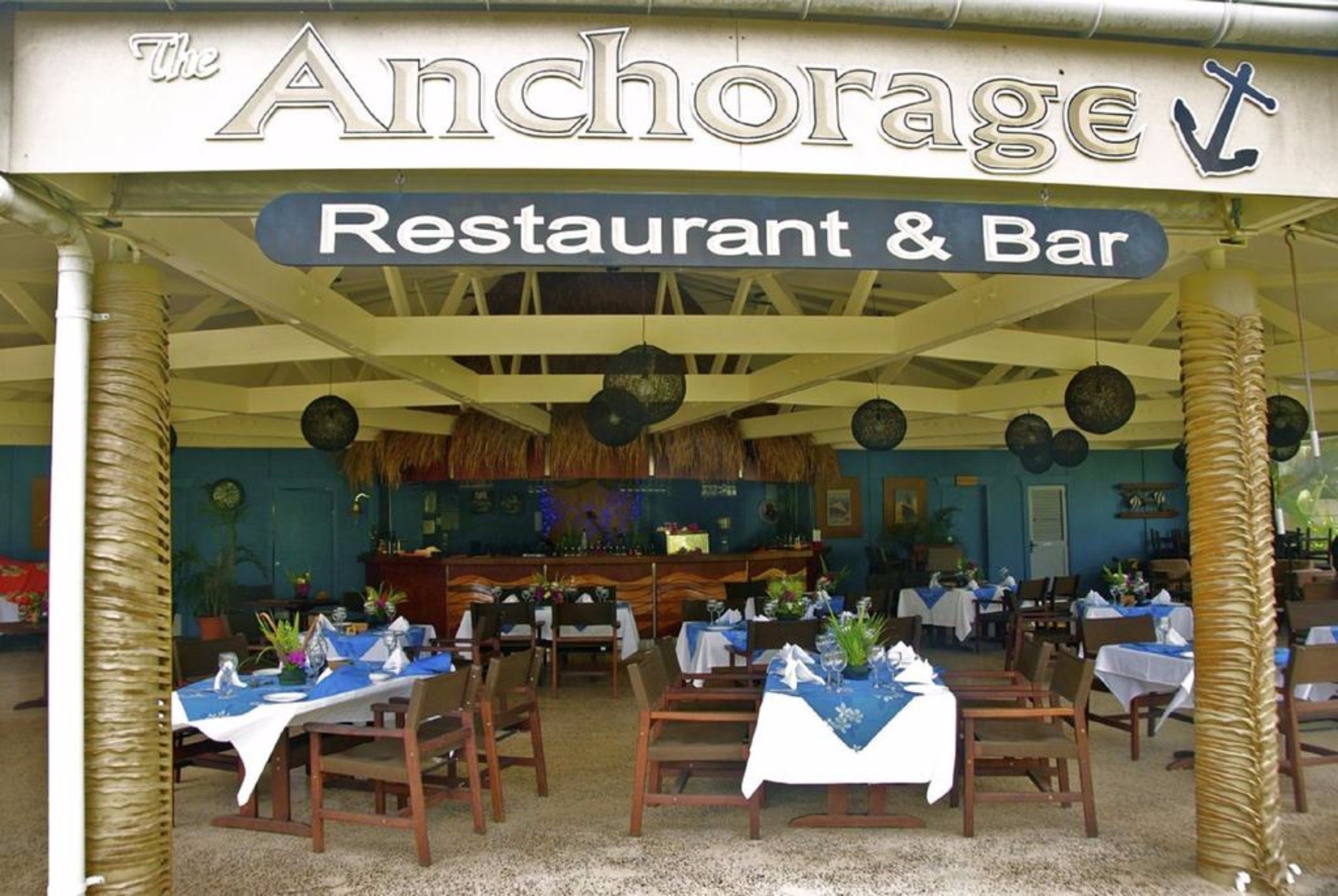 El restaurant i bar Anchorage, amb taules preparades per sopar i una zona de bar visible al fons.