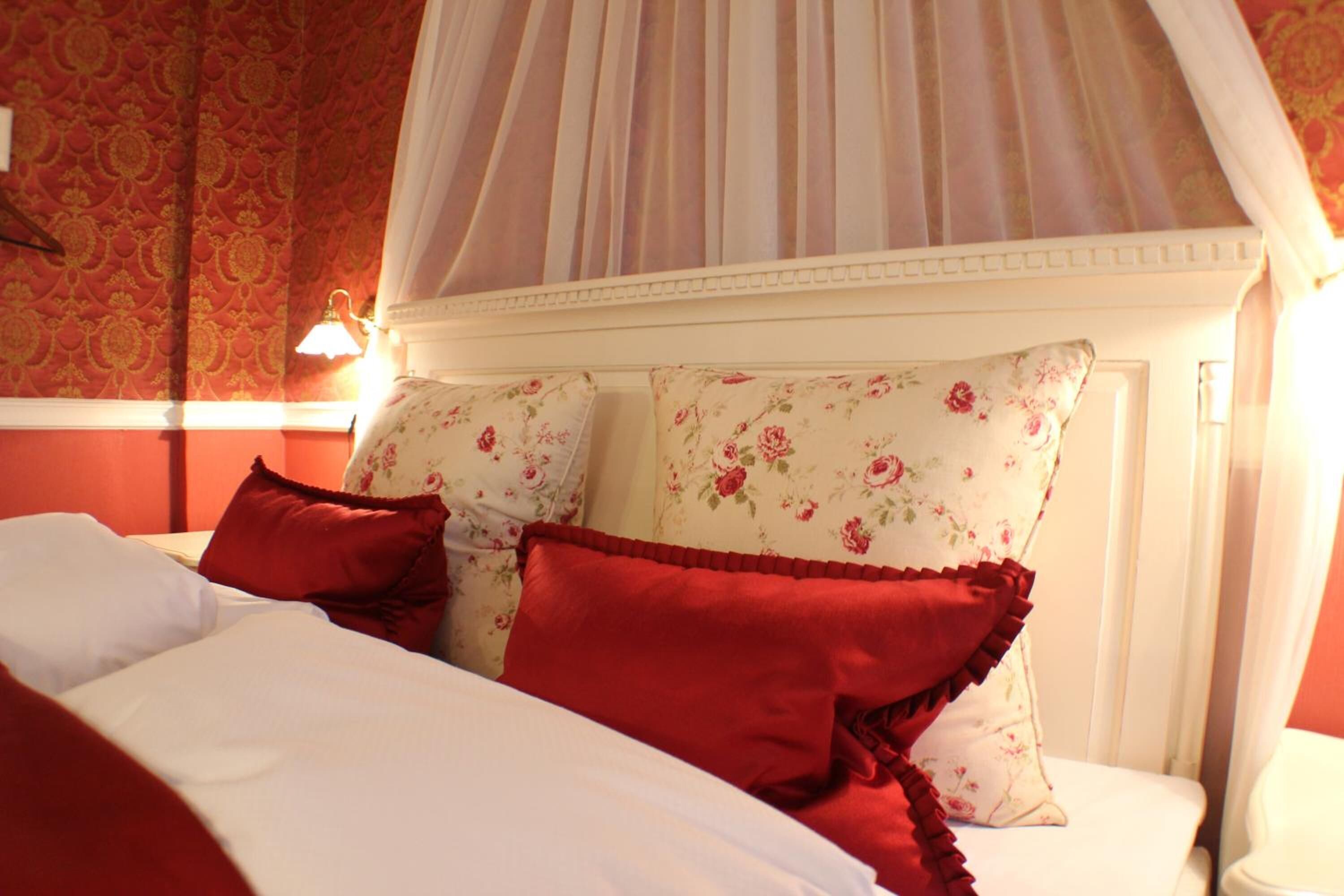 A bed with floral-patterned pillows and a canopy.