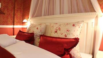 A bed with floral-patterned pillows and a canopy.