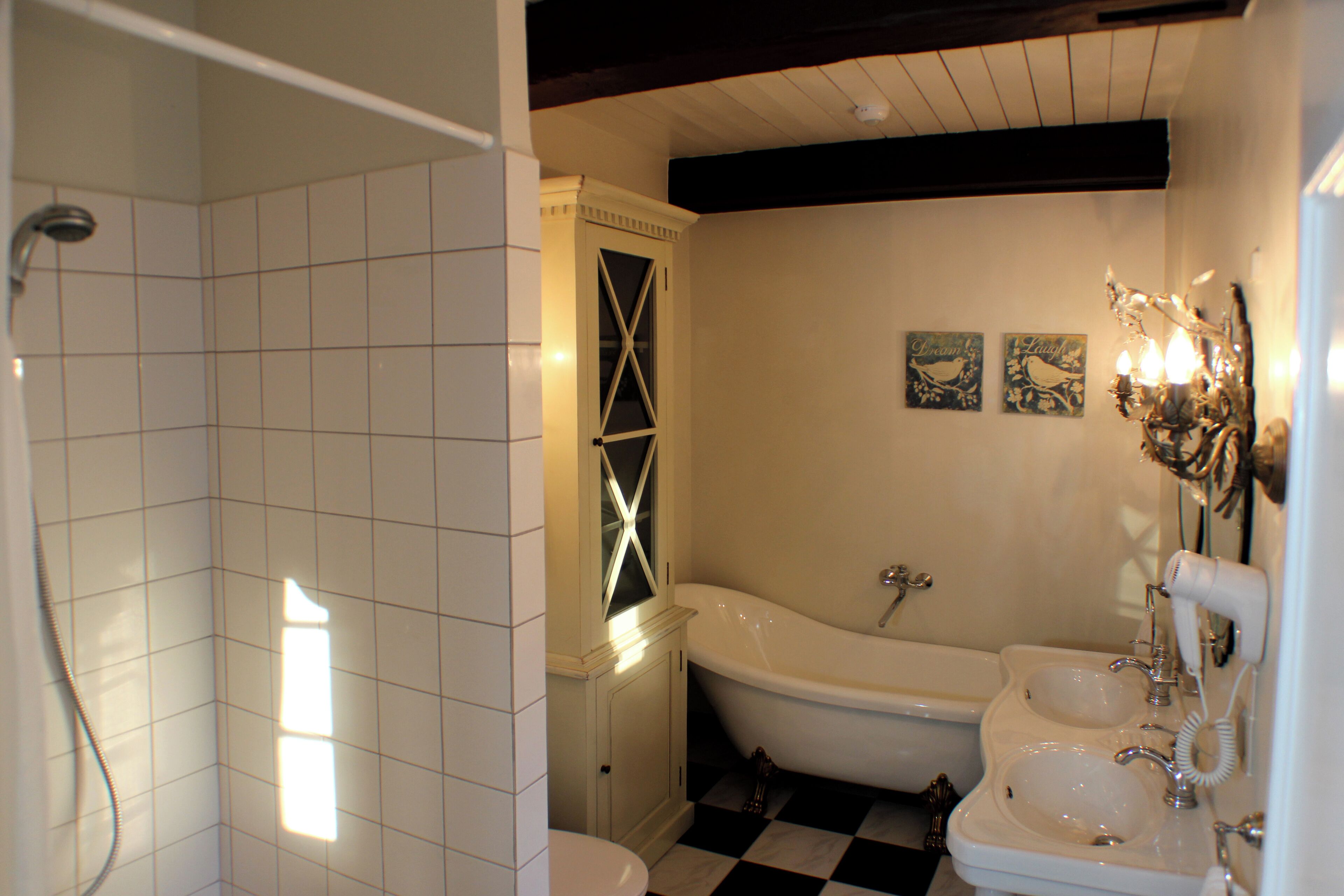 A bathroom with a bathtub, two sinks, and a shower.