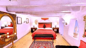 Un dormitorio con una cama grande, dos mesitas de noche, un espejo y una alfombra roja.