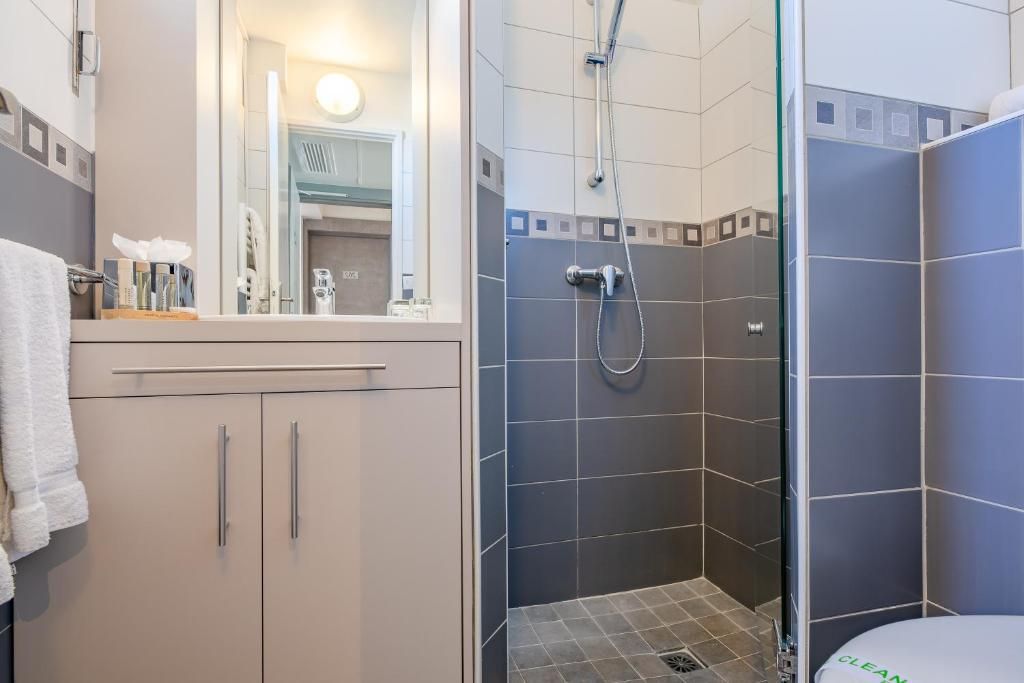 A bathroom with a shower, a mirror, and a sink.