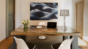 A modern conference room with a glass table, two white chairs, a laptop, a lamp, and a large abstract painting on the wall. - Hotel Meublè Sertorelli Reit (Bormio)