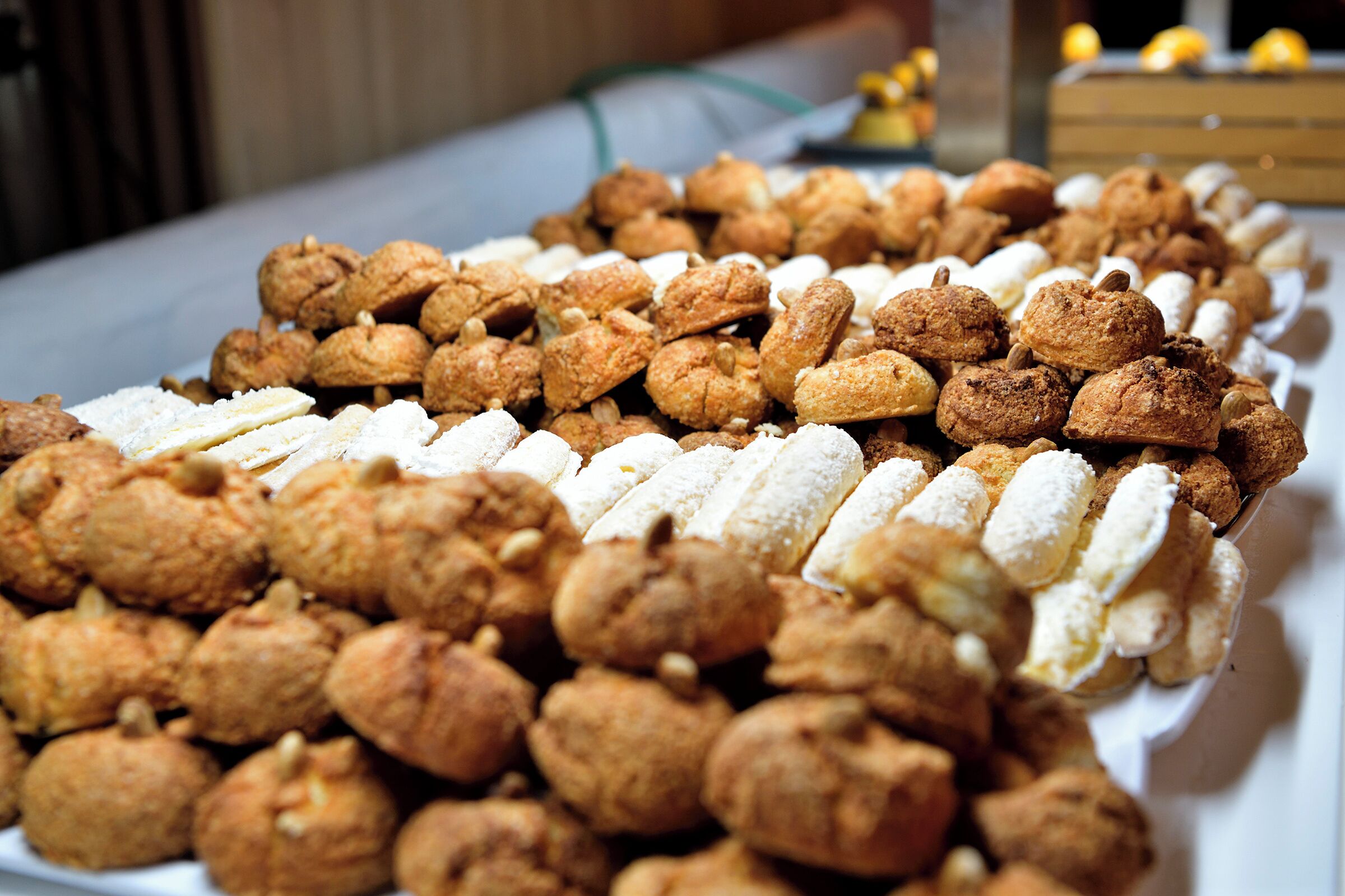 Une table garnie de diverses pâtisseries, notamment des choux à la crème et d  ’autres produits de boulangerie.