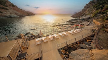 Plage privée, sable noir, chaises longues, parasols