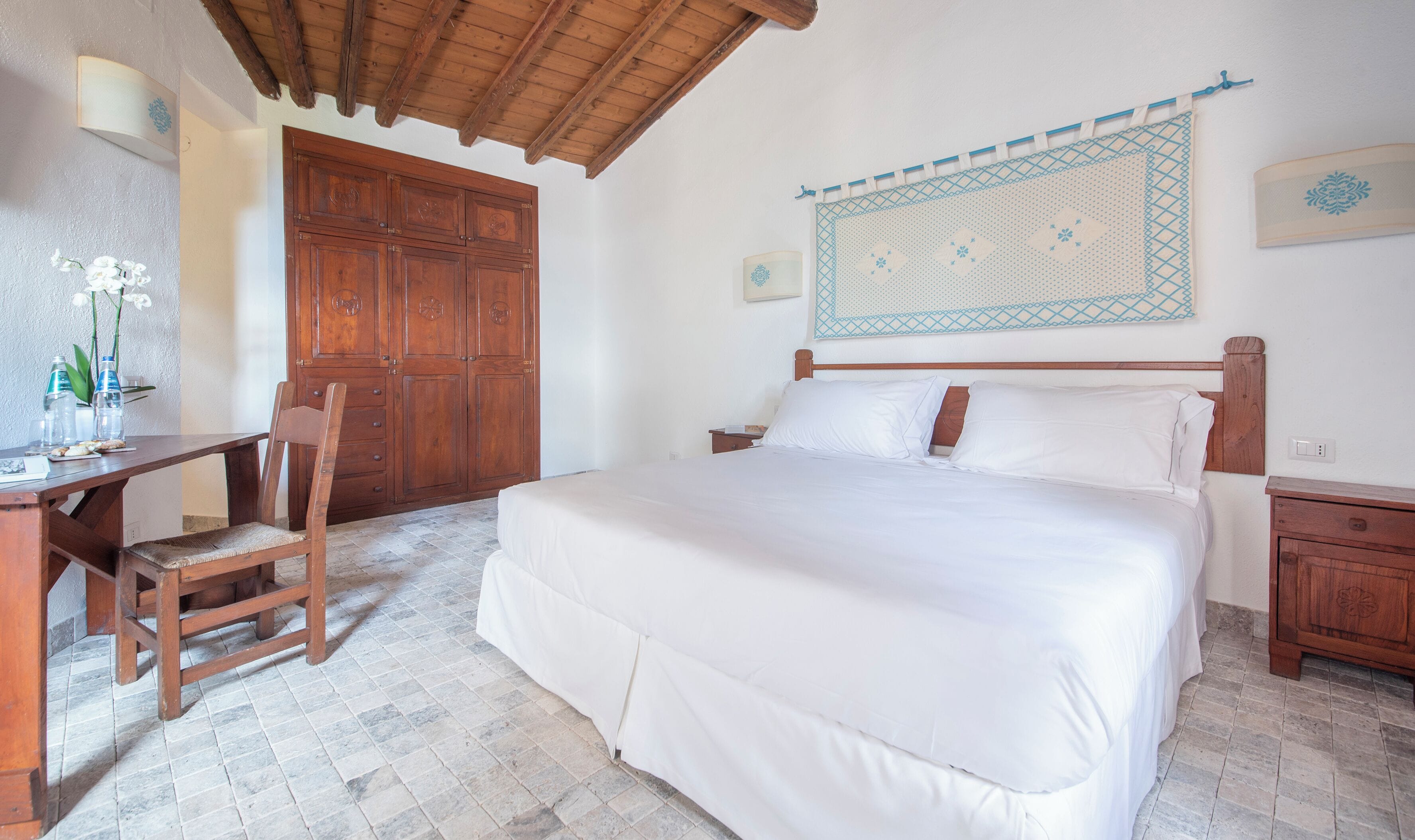 A bedroom with a wooden bed, a desk, and a chair.
