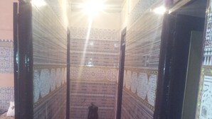 Un pasillo estrecho con paredes decoradas y suelo alfombrado.