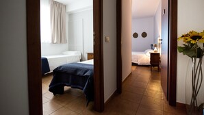 A hotel room with a bed, a bedside table, and a nightstand. There is a window with curtains and a wall-mounted clock. - Cabrera House (Pozzallo)